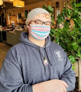 Shooltz wears her trans flag mask at Totem Bookstore, where she works (Photo by Tom Travis)